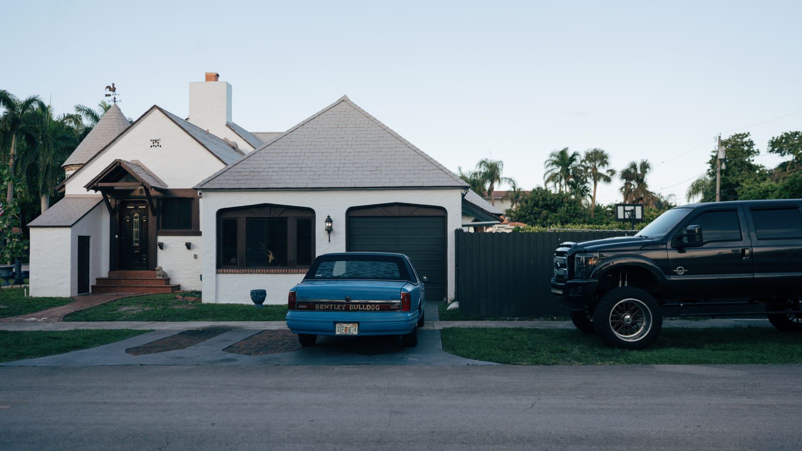 Truck and car parked in a suburban driveway