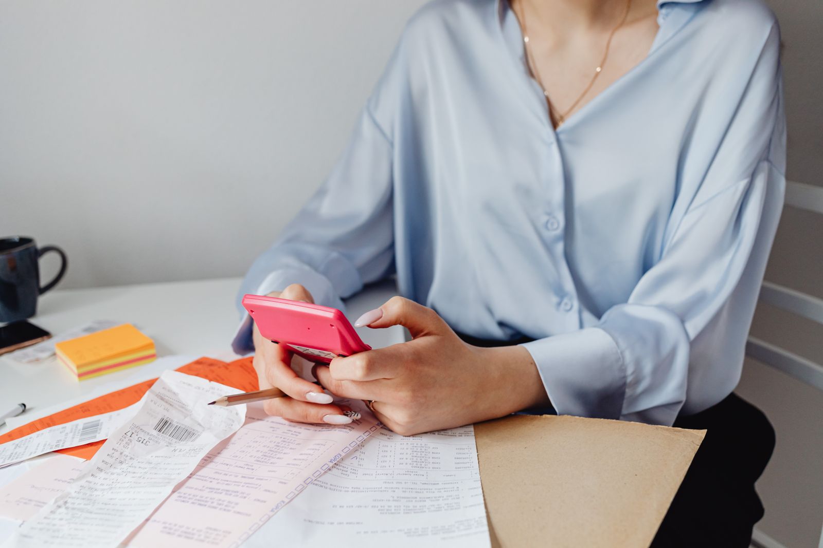 Woman comparing insurance bills with a calculator